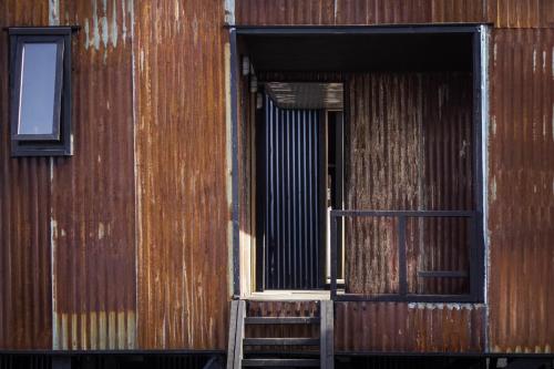 an open door of a wooden building with a ladder at El Coo Lodge in Queilén