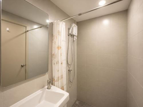 a white bathroom with a shower and a sink at Spacious Studio Near BTS Kitchen & Washer in Amphoe Phra Khanong