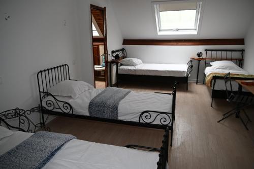 a room with three bunk beds and a window at Cottage des Moutons Espiègles in Saint-Martin-de-Nigelles
