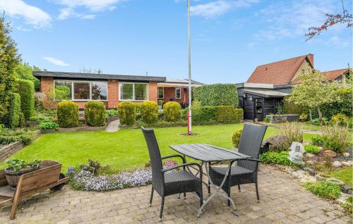 a patio with a table and chairs in a yard at 2 Bedroom Pet Friendly Home In Ringkøbing in Ringkøbing
