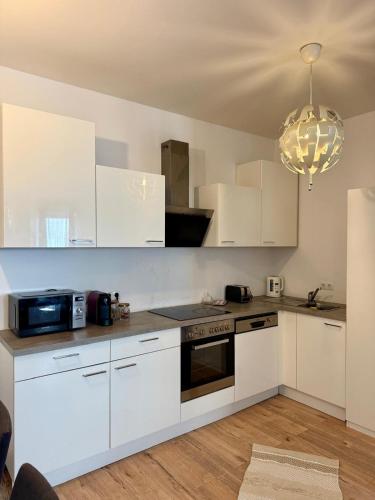 a kitchen with white cabinets and a chandelier at Excelsior in Graz