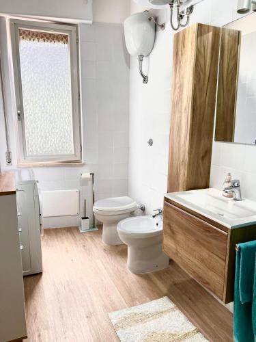 a white bathroom with a toilet and a sink at Cussorgia's House in Calasetta