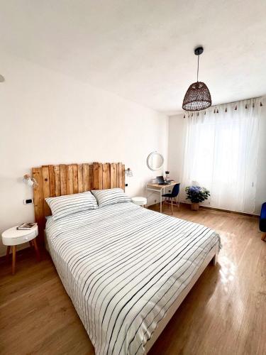 a bedroom with a large bed with a striped comforter at Cussorgia's House in Calasetta