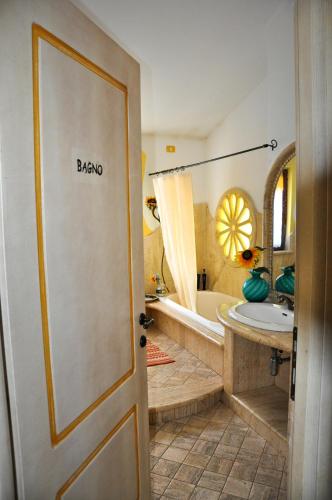 a bathroom with a tub and a sink and a door at Casa d' Artista B&B in Ozieri
