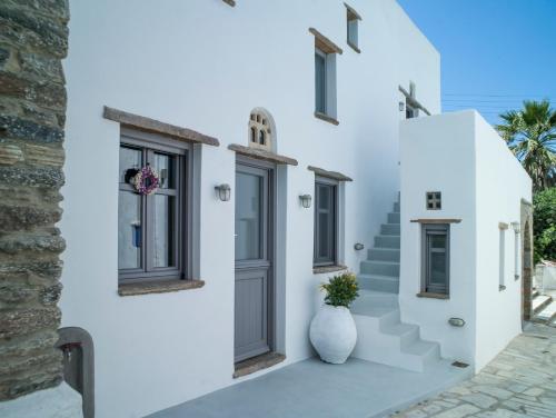 a white house with a vase on the side of it at Tutti Blu Tinos Living Space in Mési