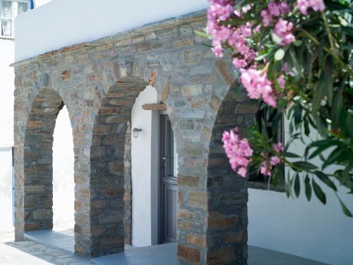 an archway with pink flowers in front of a door at Tutti Blu Tinos Living Space in Mési