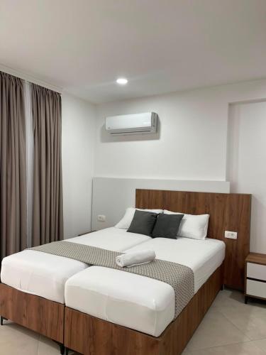 a bedroom with a large bed with a wooden headboard at Sunny Coast in Dobra Voda