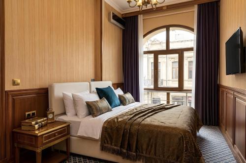a bedroom with a large bed and a window at Epicenter Hotel Baku in Baku