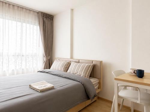 a bedroom with a bed and a desk and a window at Pool Studio Near BTS Quiet Stay in Amphoe Phra Khanong
