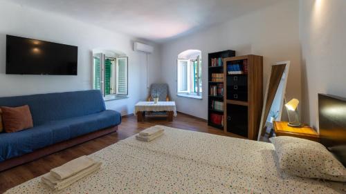 a living room with a blue couch and a tv at House Antonia by Villas Guide in Opuzen