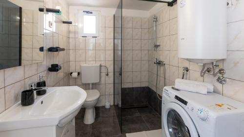 a bathroom with a washing machine and a sink at House Antonia by Villas Guide in Opuzen