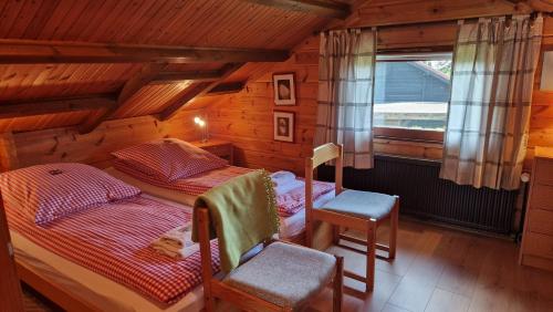 a bedroom with a bed and a chair in a cabin at Feriennest Buendorf in Dahlenburg