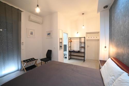 a bedroom with a bed and a chair in a room at Brindisi Airport Rooms in Brindisi