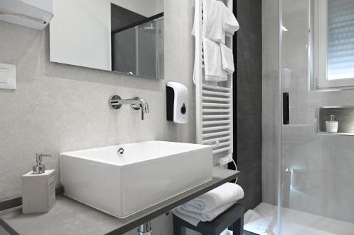 a white bathroom with a sink and a toilet at Brindisi Airport Rooms in Brindisi