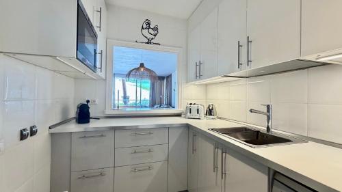 a white kitchen with a sink and a window at Puig Sa Guilla 1C B2 in Pals