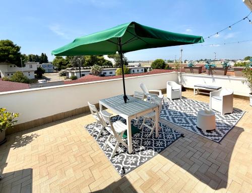 a patio with a table and umbrella on a roof at Fil Rouge in Ciampino