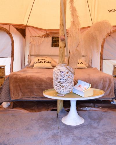 a table in front of a bed in a tent at Witte Merel Glamping in Beringen