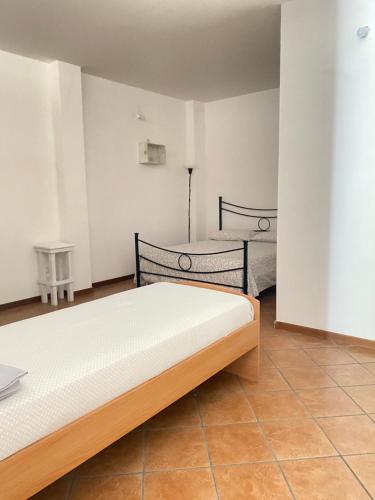 a bedroom with two beds and a tiled floor at GMD Sweet Home in Policoro