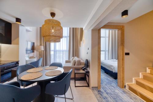 a room with a table and chairs and a bedroom at Porta Mare Active & Spa Resort in Dziwnówek