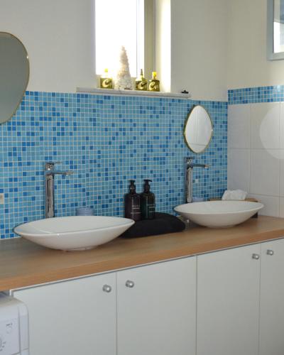 a bathroom with two sinks and blue tiles at Witte Merel Glamping in Beringen