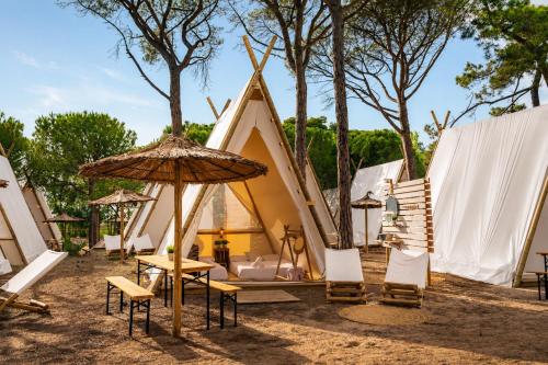 a group of chairs and an umbrella in front of a tent at Kampaoh Costa Brava in Pals