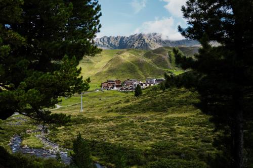 a resort on a hill with mountains in the background at AlpinLodges Kühtai in Kühtai
