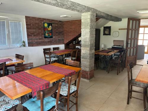 a restaurant with tables and chairs and a brick wall at Hillside Apartment Kruna in Babušnica