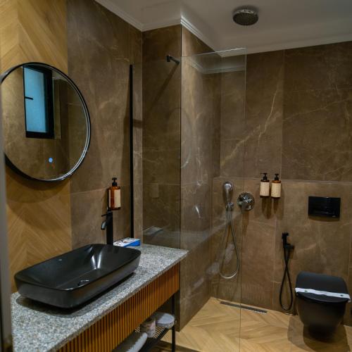 a bathroom with a sink and a shower at Belvedere Hotel in Vlorë