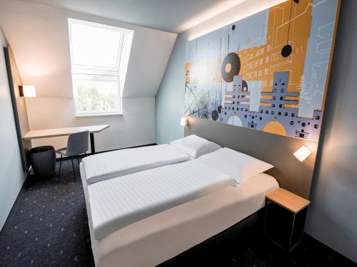 a hotel room with a bed and a desk at B&B HOTEL Wien-Heiligenstadt in Vienna