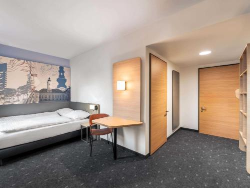a hotel room with a bed and a table at B&B HOTEL St-Pölten in Sankt Pölten