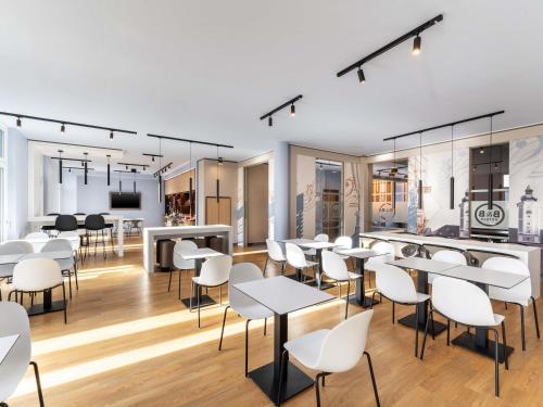 a dining room with white chairs and tables at B&B HOTEL St-Pölten in Sankt Pölten