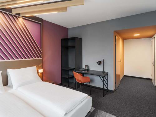 a bedroom with a bed and a desk at B&B HOTEL Klagenfurt-City in Klagenfurt