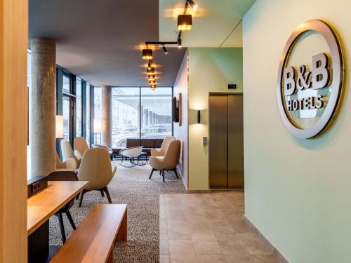 a lobby with chairs and a large mirror on the wall at B&B HOTEL Klagenfurt-City in Klagenfurt