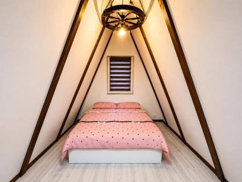 a bedroom with a bed in a triangular room at A Frame YRA cu ciubar in Câmpulung