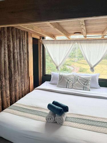 a bed in a room with a large window at เวนิสบ้านเวร in Ban Khun Nam Nan