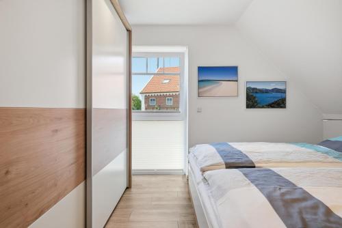 a bedroom with a bed and a window at Grachtenrefugium in Greetsiel