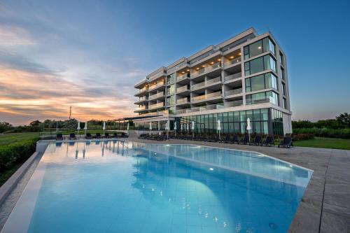 a large building with a swimming pool in front of it at Calithea Residence in Kavarna