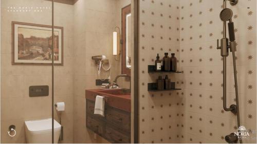 a bathroom with a shower with a toilet and a sink at The Noria Hotel in Arsuz