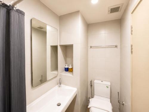 a bathroom with a sink and a toilet and a mirror at Easy Access Studio Near BTS in Amphoe Phra Khanong
