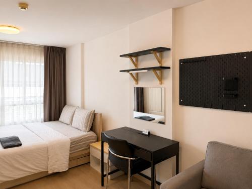 a hotel room with a bed and a desk and a couch at Easy Access Studio Near BTS in Amphoe Phra Khanong