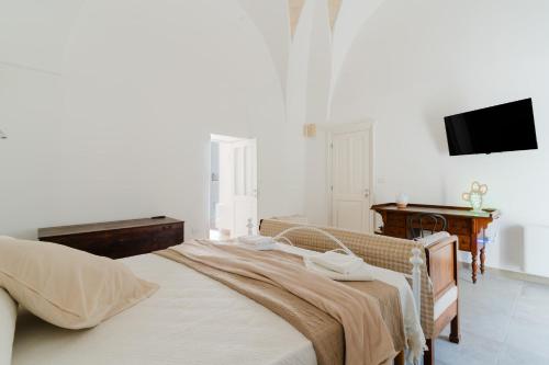 a bedroom with a bed and a desk and a television at Dimora storica Jolanda a Uggiano in Uggiano la Chiesa