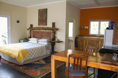 a bedroom with a bed and a table and a television at Hangman's Lookout in Calitzdorp