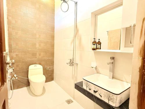 a bathroom with a toilet and a sink at Highland by Gunner Lodges in Patriata