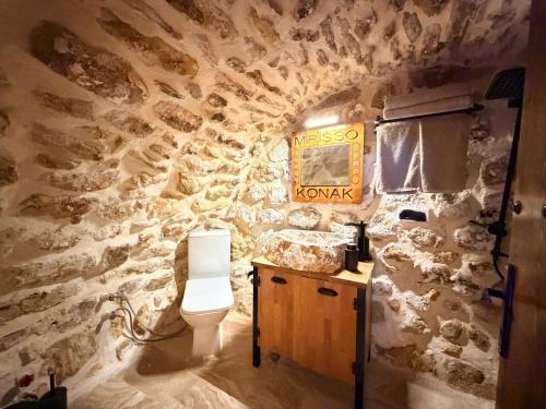 a bathroom with a toilet in a stone wall at Mirisso Konak Mardin in Mardin