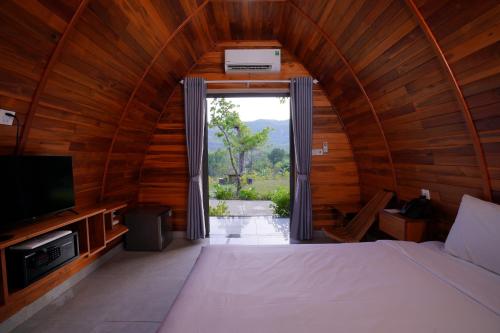 a bedroom with a large bed and a large window at Blue Haven Resort Quy Nhơn in Quy Nhon