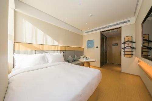 a large white bed in a hotel room at JI Hotel Beijing Happy Valley in Beijing