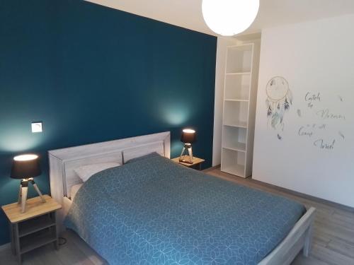 a bedroom with a bed and a blue wall at Gîte Aux 3 Épis, Classé 3 Étoiles in Dienville