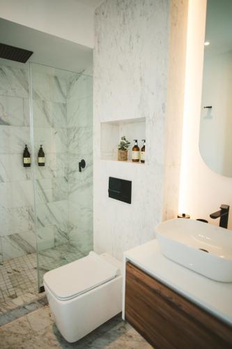 a white bathroom with a toilet and a sink at Icon 701- Stylish Loft W AC Premium Location in Mexico City