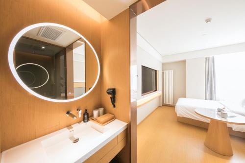 a bathroom with a sink and a mirror at JI Hotel Beijing Happy Valley in Beijing