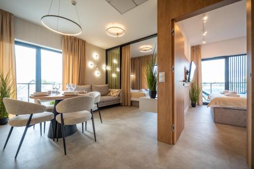 a hotel room with a dining table and a bedroom at Apartament K&M 13 in Mikołajki